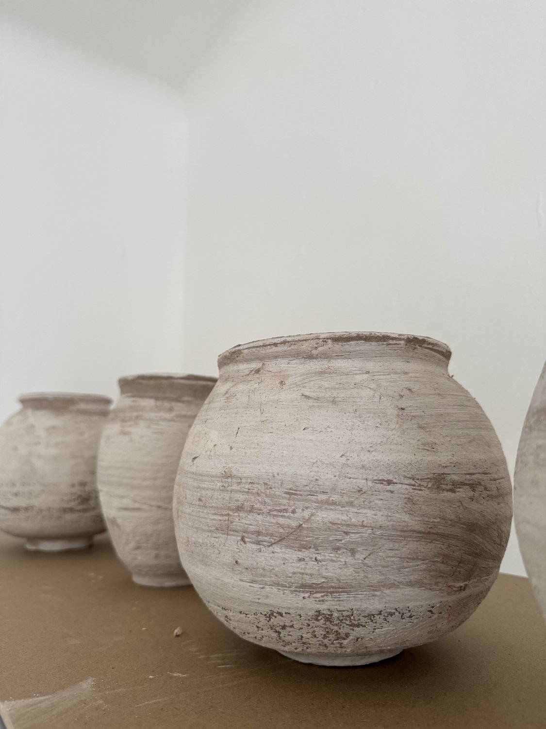 Piezas de gres en crudo en las estanterías del taller